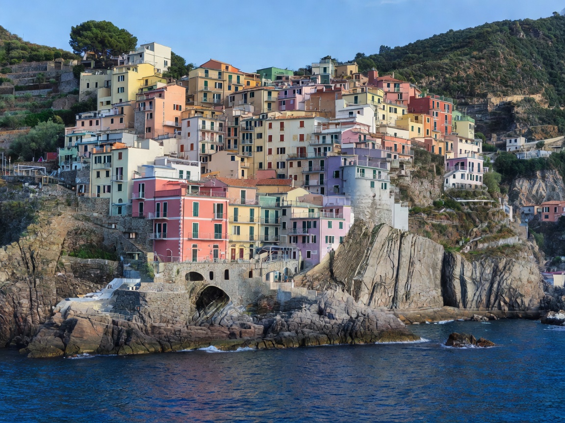Pastel houses stacked on steep cliff terraces above a blue southern Italian sea